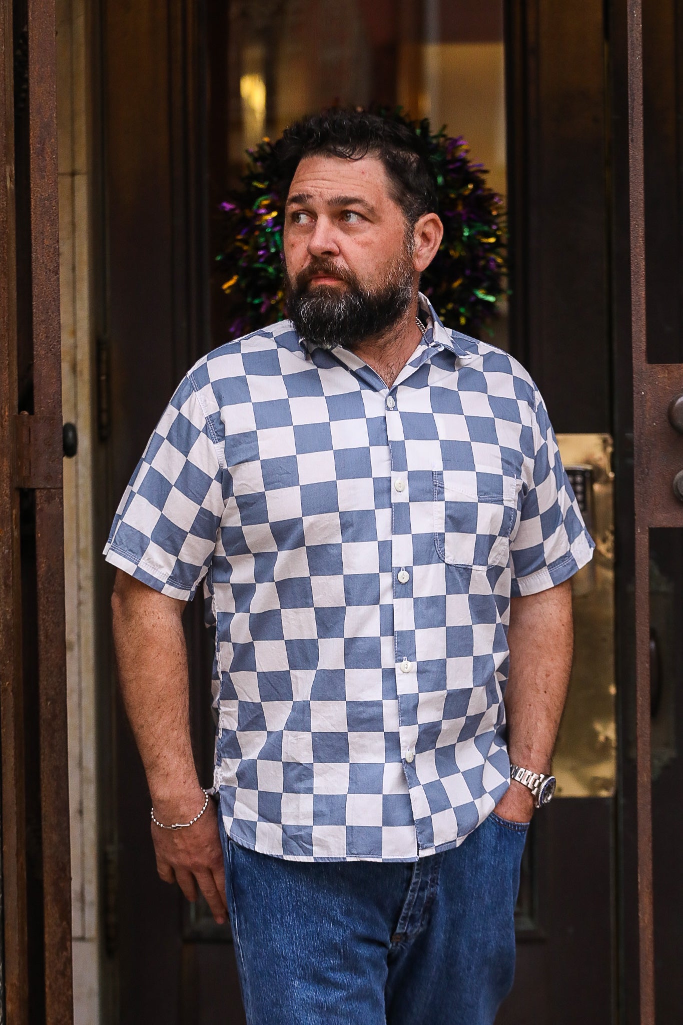 Man in Blue and White Plaid Shirt and Denim Jeans Standing on